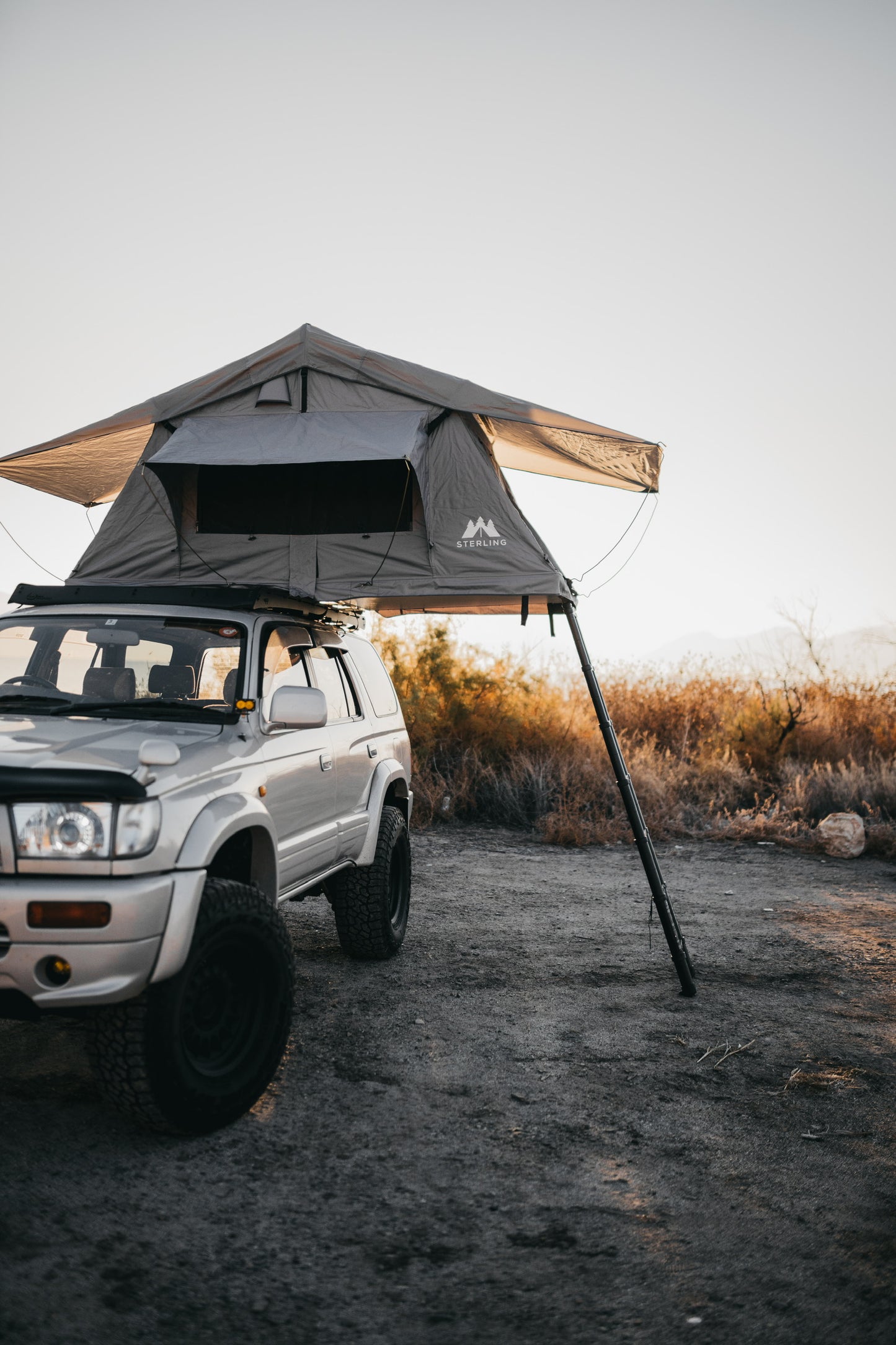 close up shot of open Soft Shell tent with logo and ladder extended on a Hilux Surf